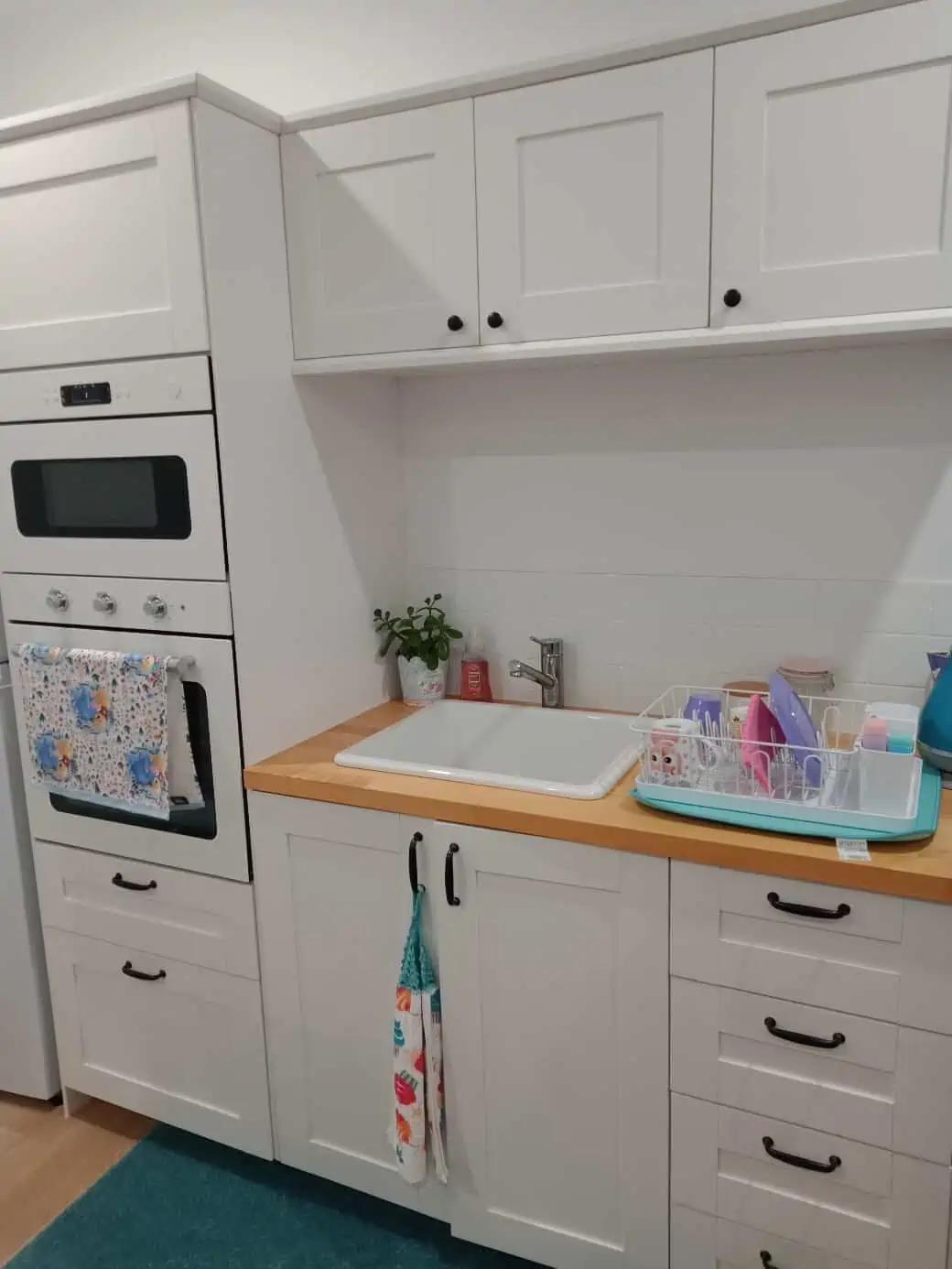 White kitchen unit with wooden countertop in a portable park cabin